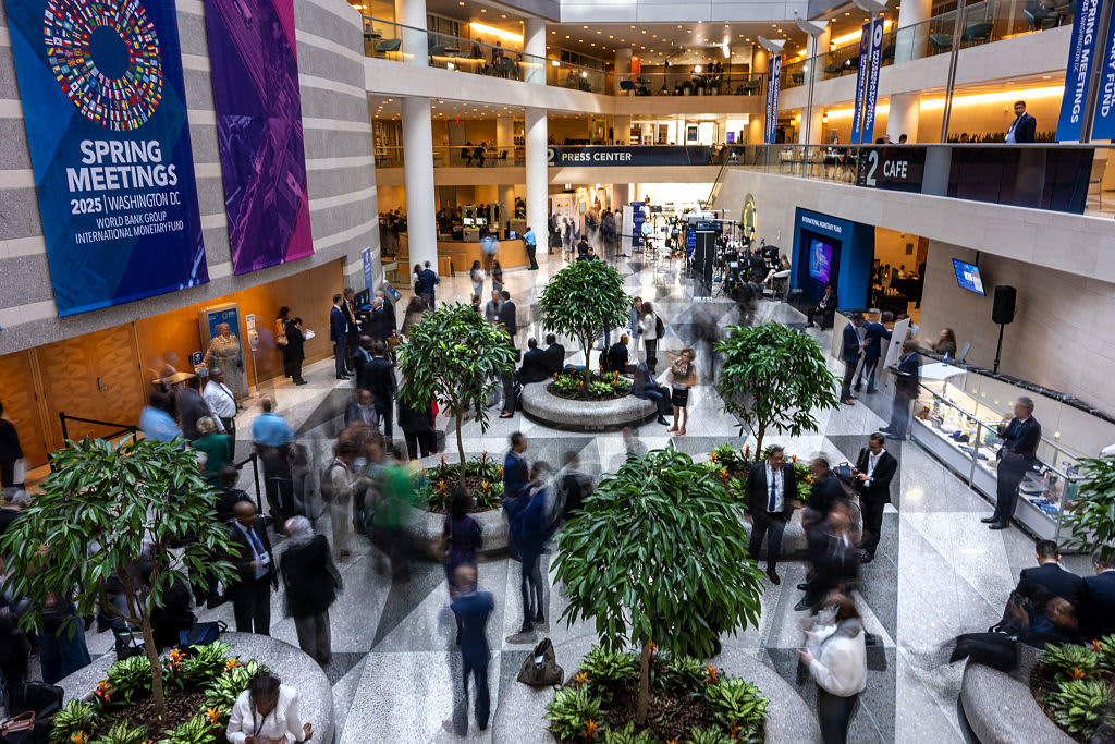 Guests and attendeess mingle and walk through the atrium during the IMF/World Bank Group Spring Meetings at the IMF headquarters in Washington, DC, on April 24, 2025. 