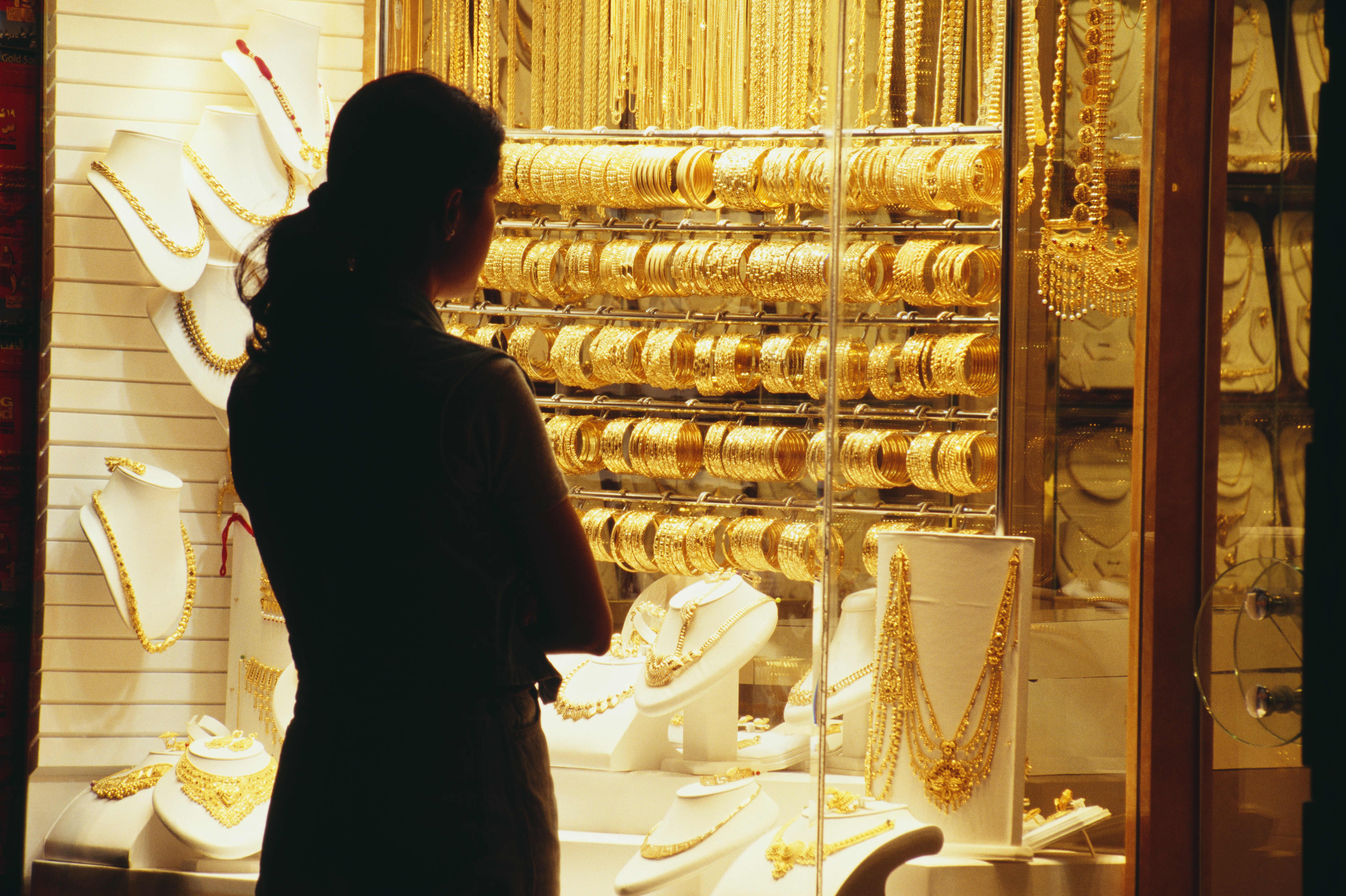 A woman looks at the jewelry displayed at a jewelry shop.